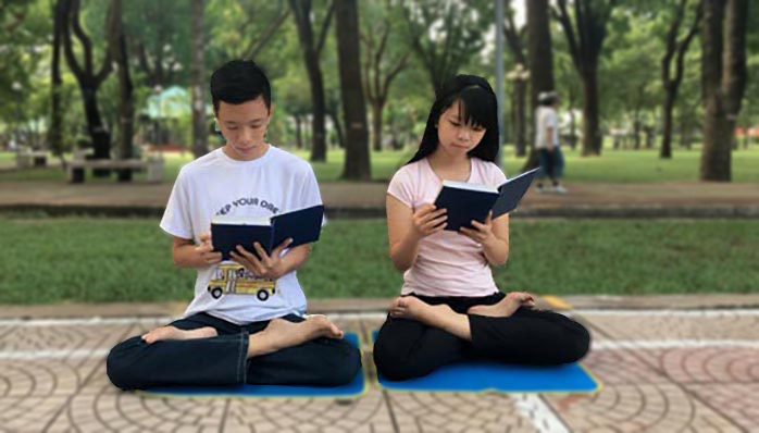 Hai con của chị Lánh đang đọc cuốn Chuyển Pháp Luân của Pháp Luân Công. Sau khi chứng kiến huyền năng của Phật Pháp, các em cũng bắt đầu chân chính bước chân vào tu luyện. (Ảnh tác do giả cung cấp).