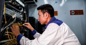 Đỗ Quang Thủy kiểm tra hệ thống cáp tại phòng thiết bị trong quá trình vận hành các trạm viễn thông vùng núi Chí Linh, Hải Dương.