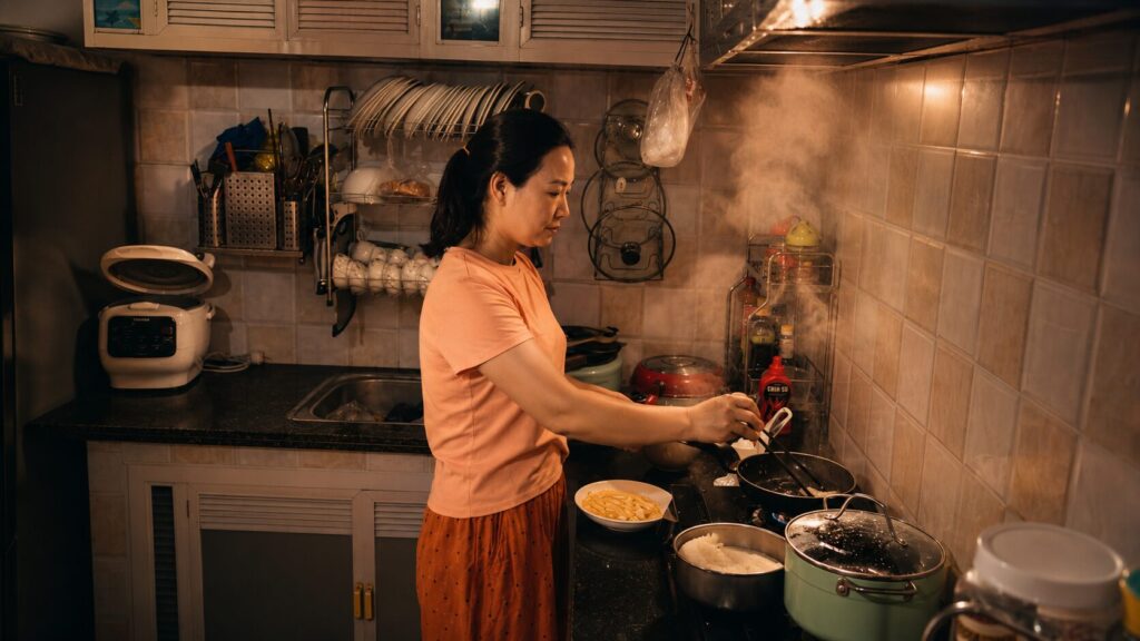 Chị Phan Thị Lợi chuẩn bị bữa cơm cho gia đình tại nhà, minh họa nhịp sống thường ngày sau hành trình vượt ung thư vòm họng.