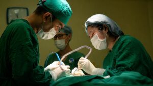 Hình ảnh bác sĩ đang thực hiện ca phẫu thuật trong phòng mổ với quy trình vô trùng, minh họa cho các bài viết về y tế và phẫu thuật.