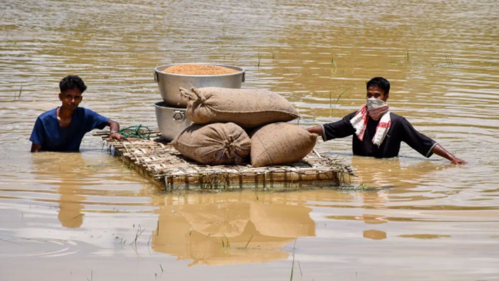 Lũ lụt nghiêm trọng tại bang Assam khiến người dân gặp nhiều khó khăn, phải vận chuyển lương thực bằng bè qua vùng ngập nước.