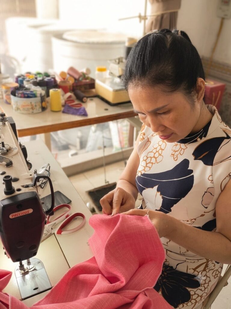 Bà Lê Thị Minh Khuyên làm việc bên chiếc máy may tại nhà ở huyện Yên Lạc, nơi gắn bó với nghề may và cuộc sống thường ngày sau nhiều biến cố.