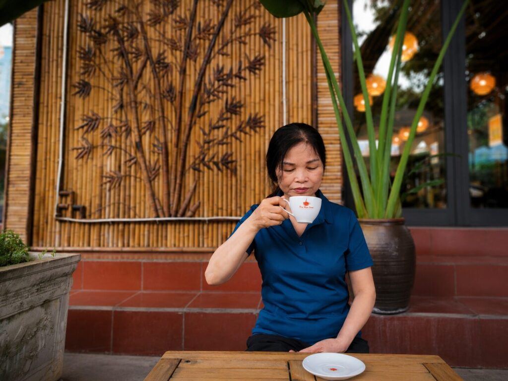 Nguyễn Thị Minh thưởng trà trong không gian yên tĩnh tại Vĩnh Yên, hình ảnh minh họa cuộc sống hiện tại sau nhiều năm làm nữ hộ sinh.
