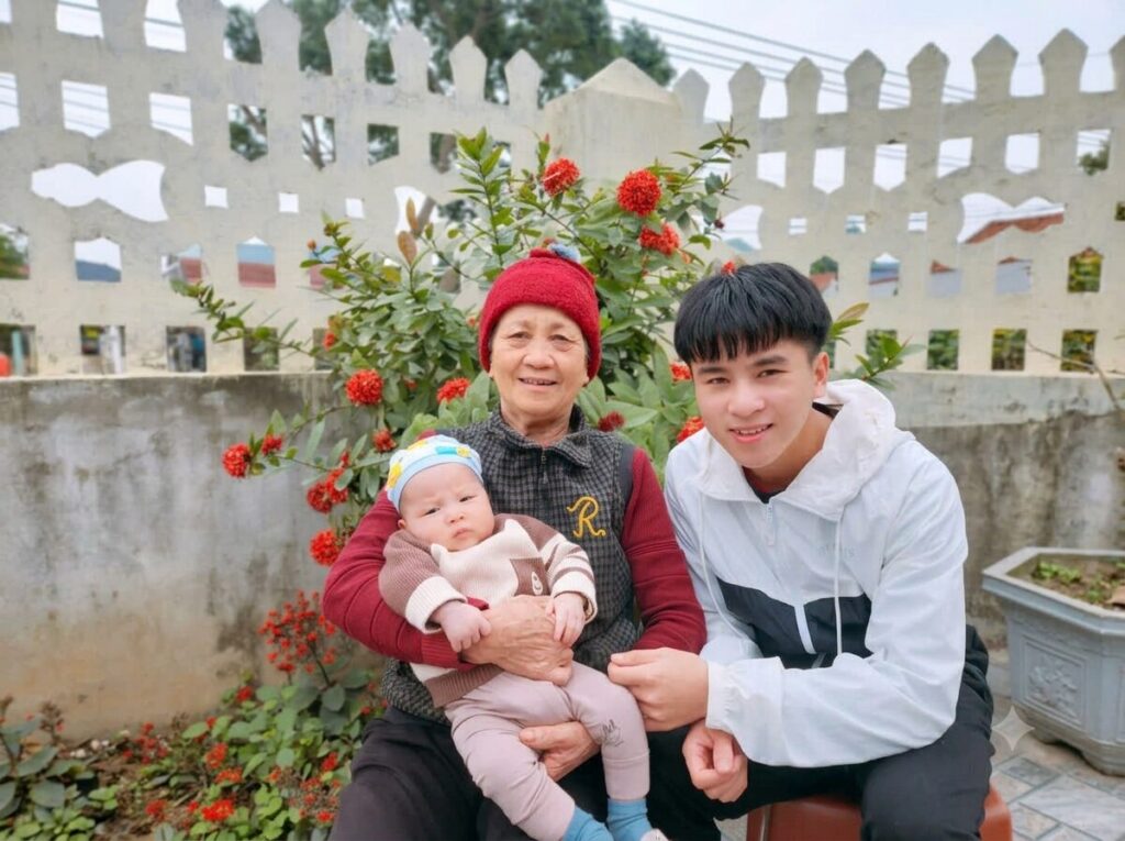 Bà Nguyễn Thị Sinh chụp ảnh cùng cháu nhỏ và người thân trước sân nhà tại xã Biện Thượng, huyện Vĩnh Lộc, Thanh Hóa.