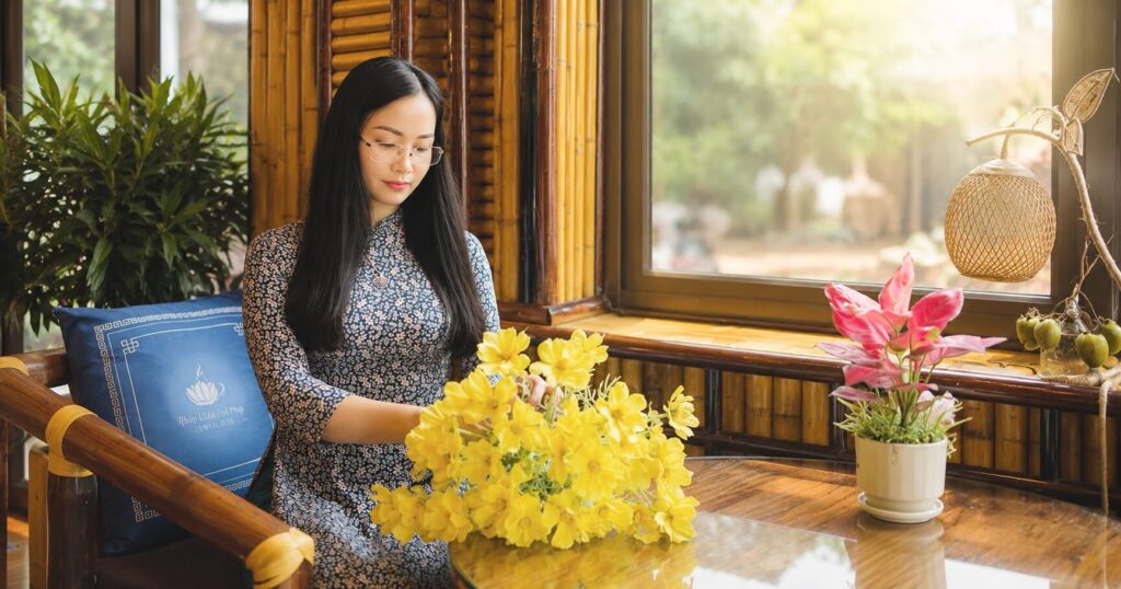 Chị Thủy Vĩnh Phúc ngồi bên bàn hoa tại quán Tinh Hoa, hình ảnh mở đầu phác họa cuộc sống bình yên sau hành trình nhiều biến cố.