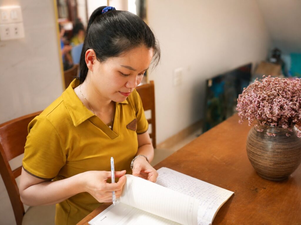 Nguyễn Thị Ánh Văn đọc và ghi chép trong không gian làm việc tại nhà. Việc đọc sách là một phần trong quá trình tìm hiểu và thực hành Pháp Luân Công.