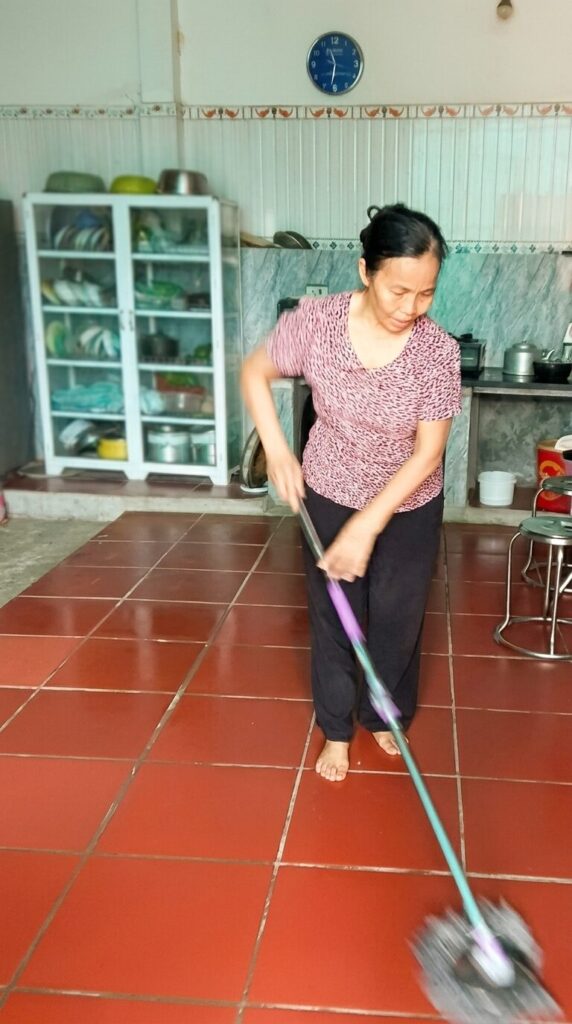 Bà Nguyễn Thị Thanh dọn dẹp nhà cửa tại xã Biện Thượng, Thanh Hóa, trong không gian sinh hoạt thường ngày của gia đình cựu thượng tá.