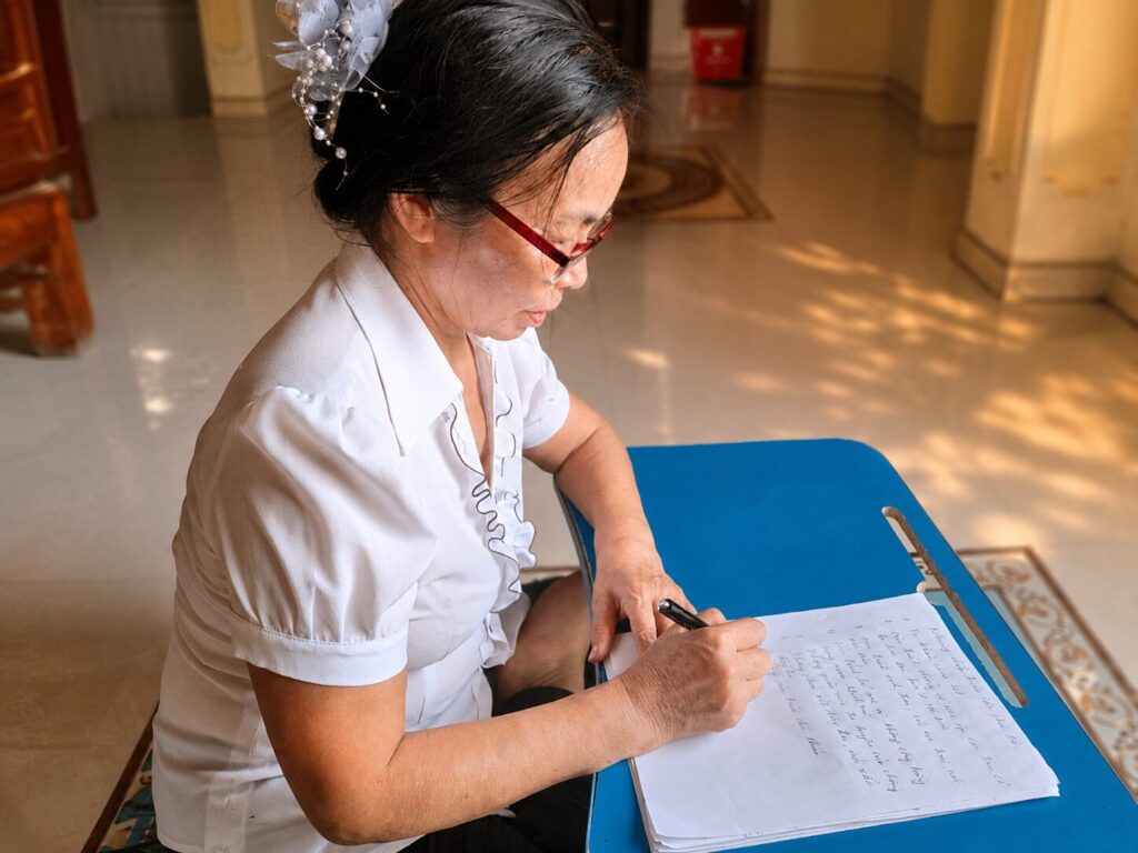 Bà Nguyễn Thị Thanh ghi chép tại nhà riêng ở xã Biện Thượng, Thanh Hóa, trong không gian sinh hoạt hằng ngày.