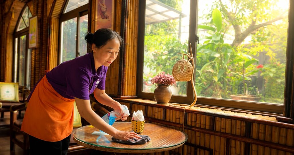 Hà Thị Ngọc Lan lau dọn bàn tại quán cà phê ở Vĩnh Phúc, nơi bà bắt đầu cuộc sống mới sau nhiều biến cố trong hành trình đổi đời.