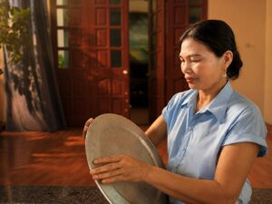 Chị Nguyễn Thị Thúy cầm chiếc mâm từng bị móp méo trong thời gian chịu bạo lực gia đình, nay trở thành dấu tích của hành trình vượt qua bạo lực gia đình.